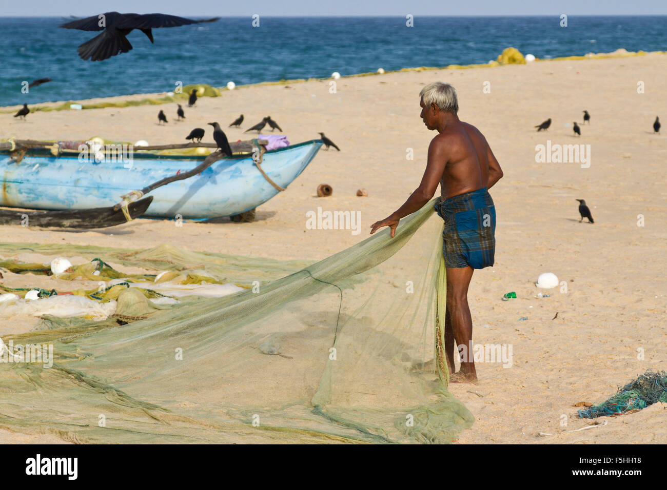 Pescatore tradizionale in canoa a Batticaloa, Sri Lanka Foto Stock