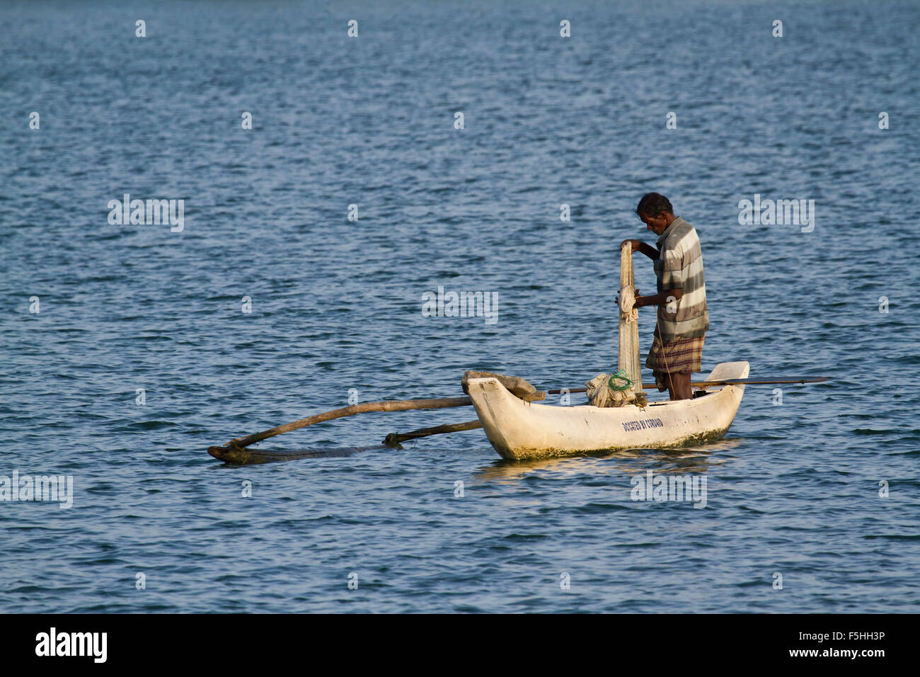 Pescatore tradizionale in canoa a Batticaloa, Sri Lanka Foto Stock