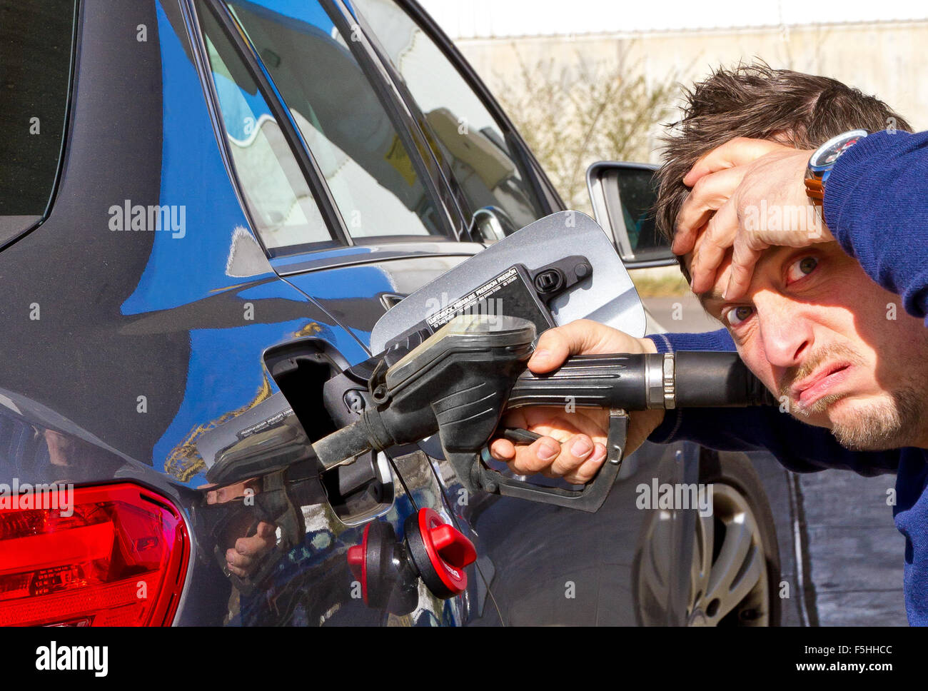 Uomo frustrato su una stazione di rifornimento di carburante Foto Stock