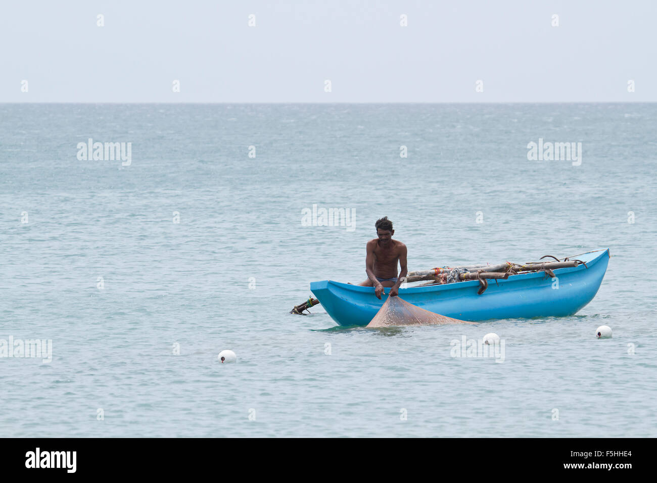Pescatore tradizionale in spiaggia Uppuveli, Sri Lanka Foto Stock