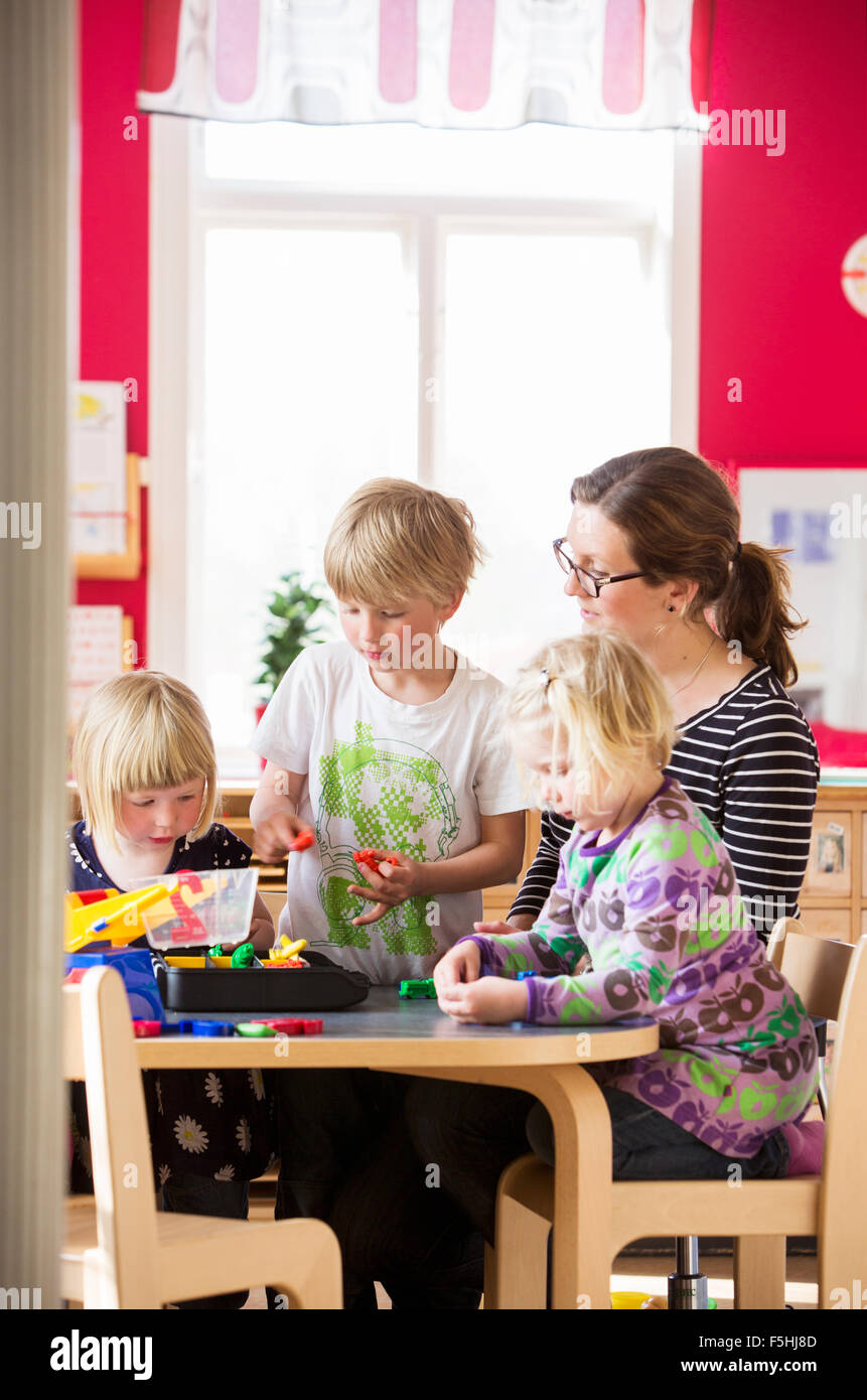 La Svezia, bambini che giocano con insegnante in una scuola materna Foto Stock