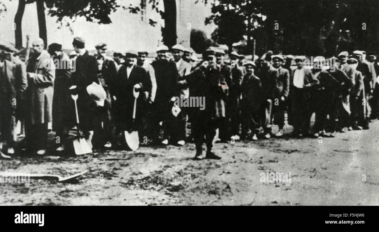 Gruppo di lavoro forzato con la pala in mano Foto Stock
