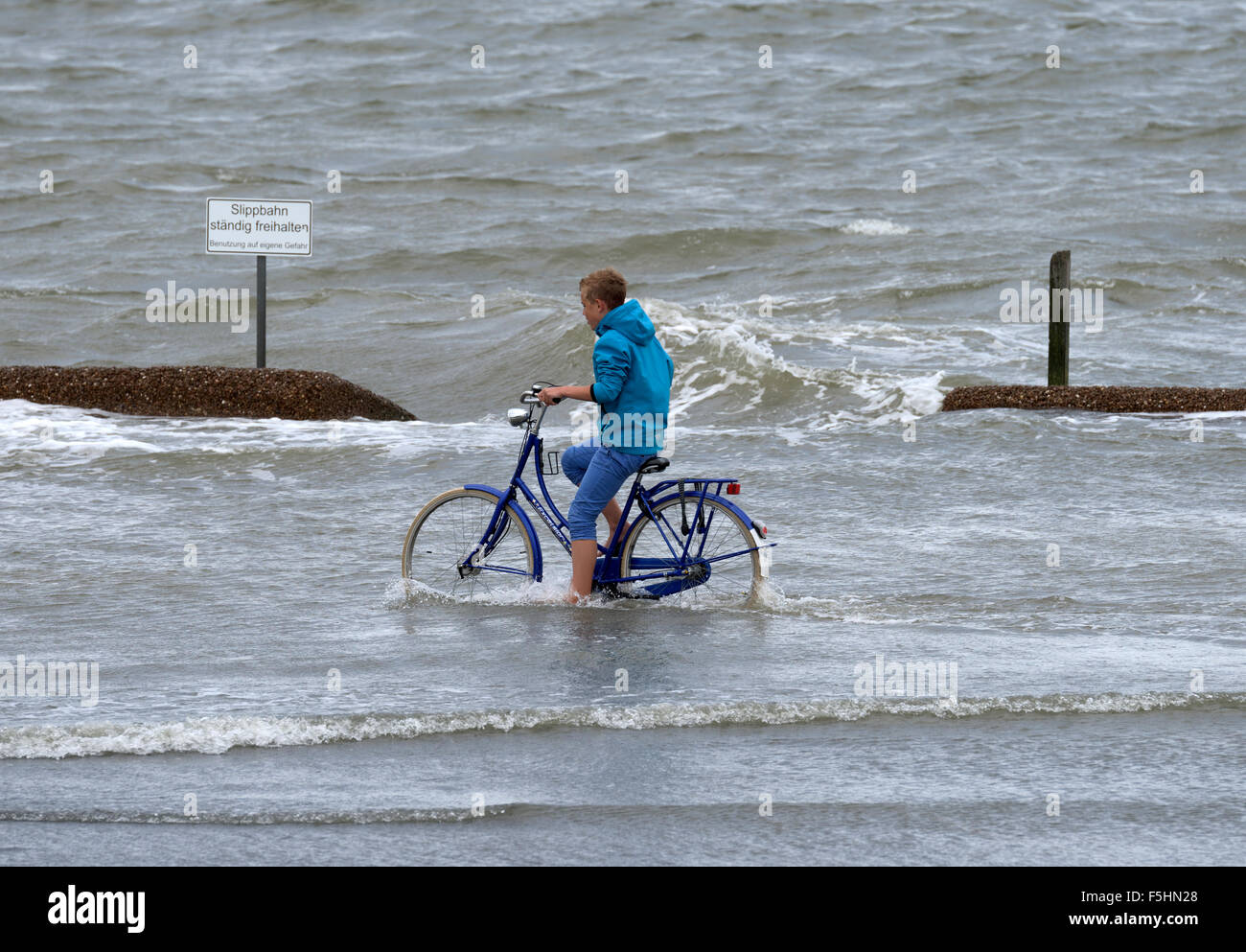 Cuxhaven, Germania, un ciclista nel diluvio Foto Stock