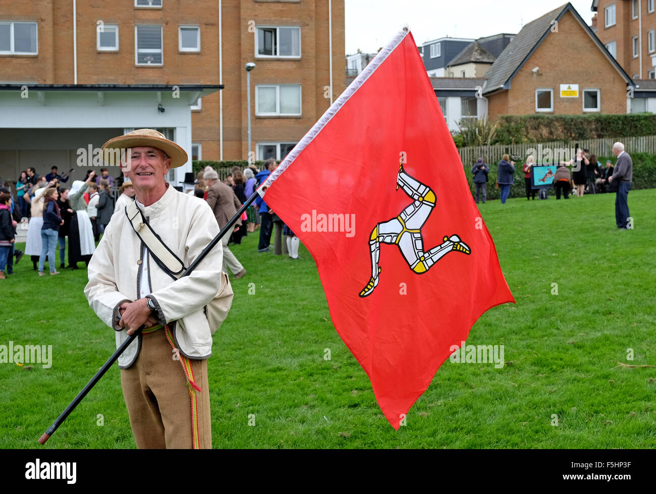 Uomo in abito tradizionale e portando la bandiera dell'Isola di Man in occasione del Festival di musica celtica svoltasi a Newquay, Cornwall, Regno Unito Foto Stock