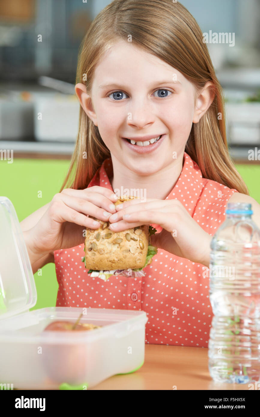 Femmina allievo seduto a tavola in mensa scolastica mangiare sano il pranzo al sacco Foto Stock