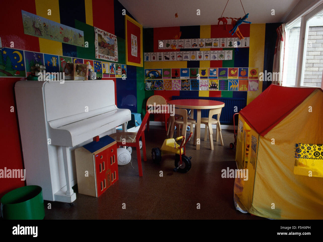 Dipinto di bianco il pianoforte e la stoffa gialla playhouse di bambini Sala giochi degli anni settanta Foto Stock