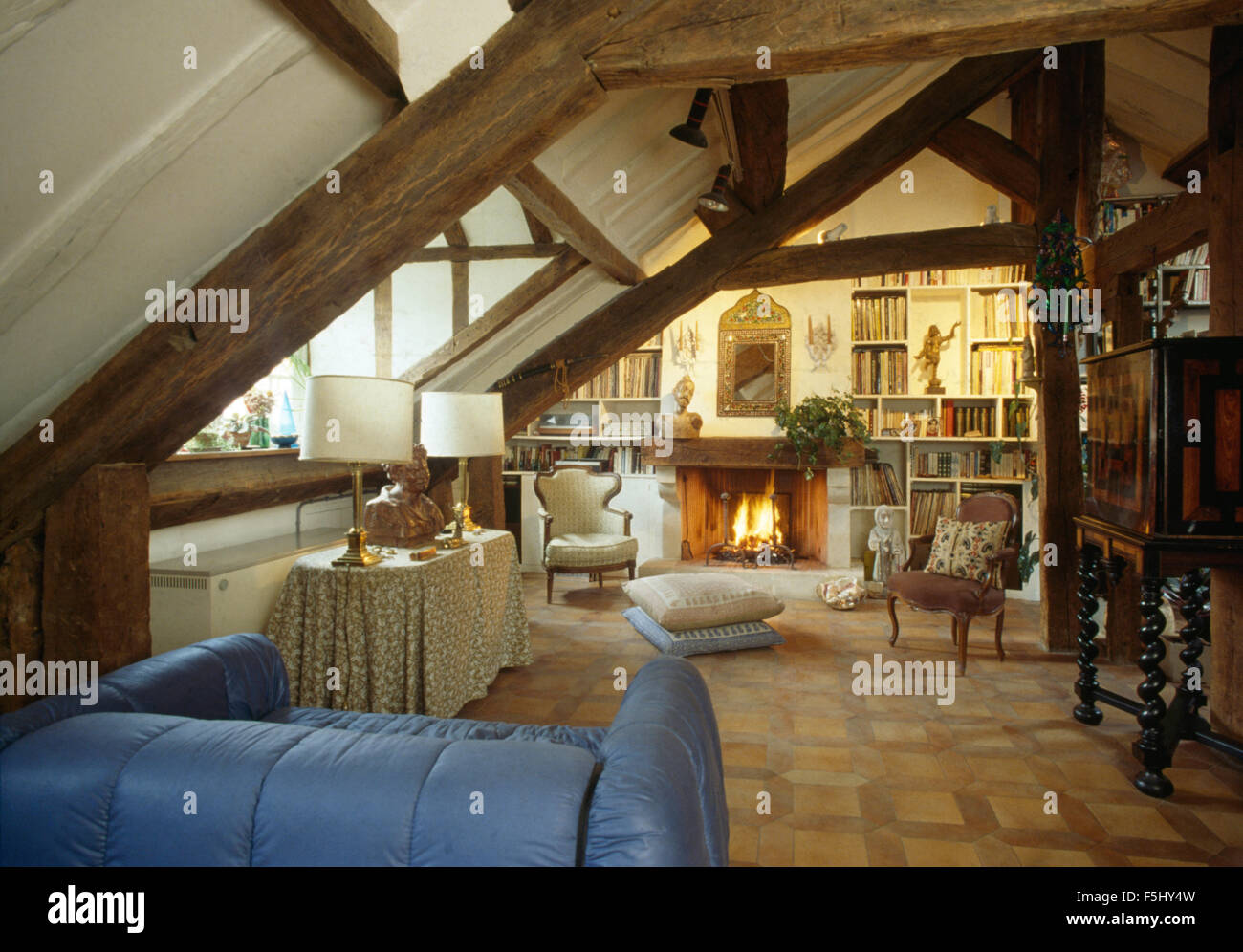 Divano blu a Parigi appartamento loft con acceso il fuoco nel camino Foto Stock