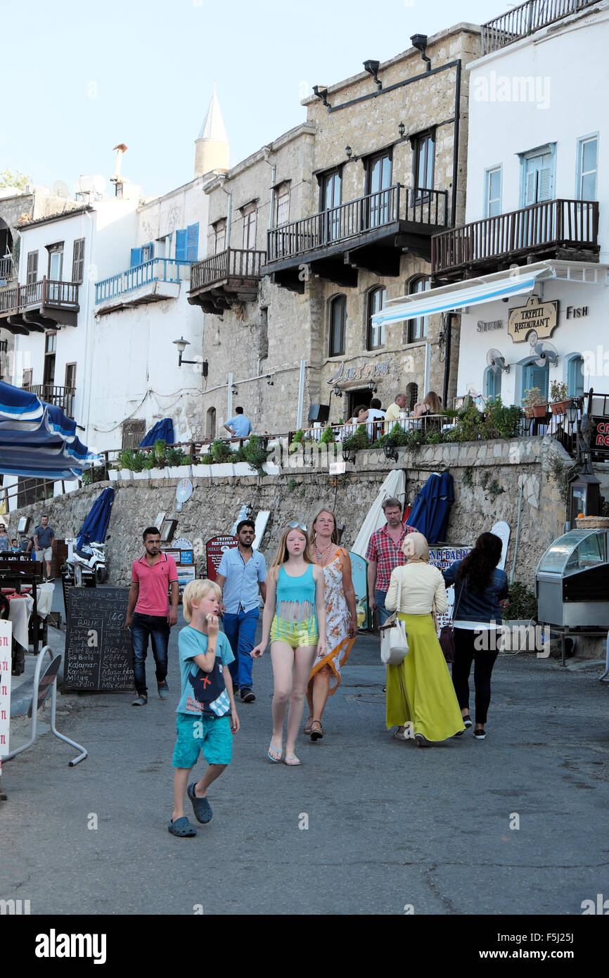 Famiglia turistici passeggiate lungo il fronte del porto in un Kyrenia seafront street Girne Cipro del Nord KATHY DEWITT Foto Stock