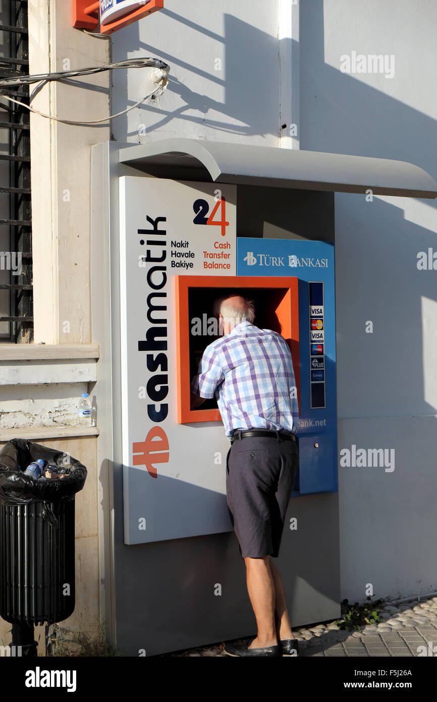 Un uomo con il Turco cashmatik Bankasi bancomat in Kyrenia Girne in lingua turca di Cipro Nord KATHY DEWITT Foto Stock