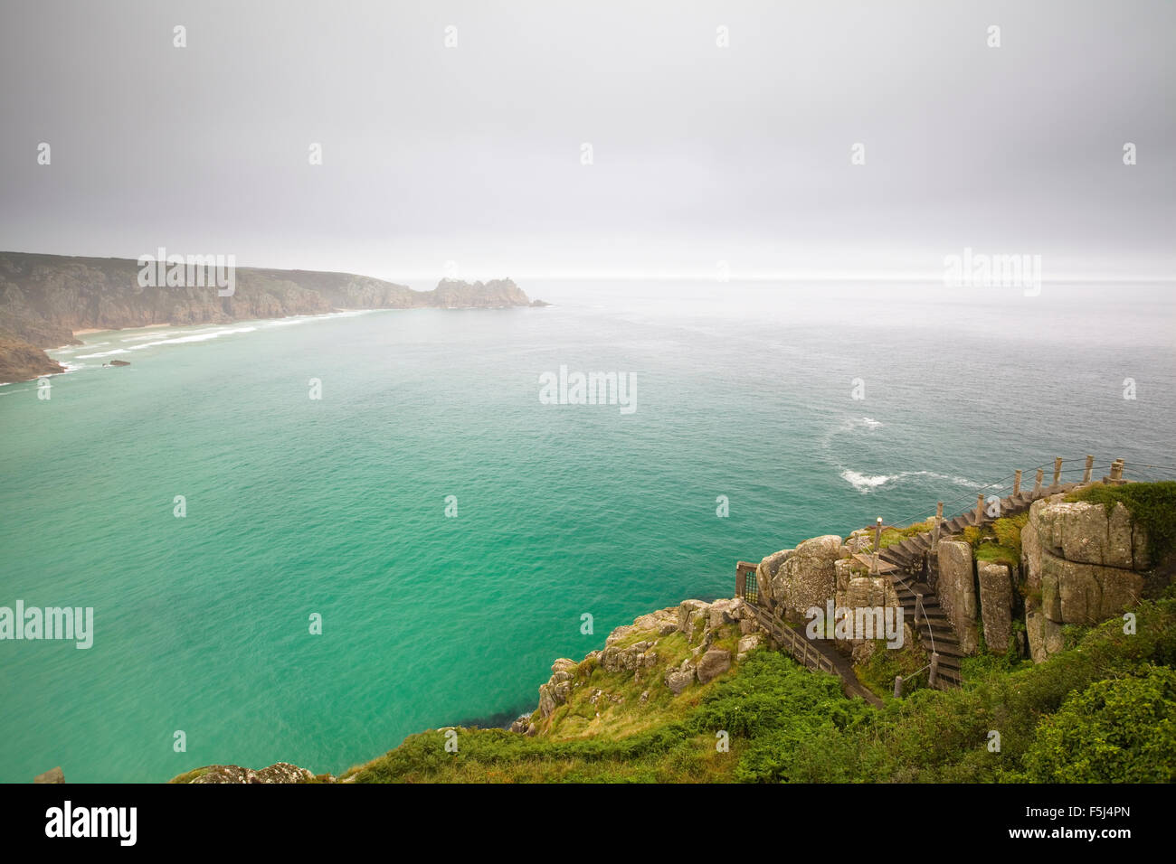 Nuvoloso vista verso Logan Rock da Porth Curno, Cornwall, Inghilterra Foto Stock