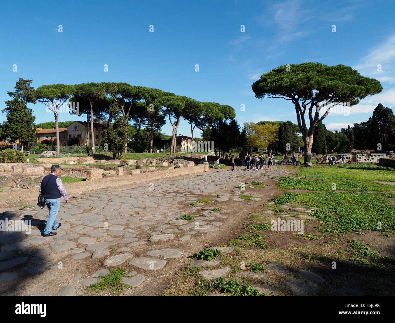 La principale strada di accesso via decumana a Ostia Antica sito dello scavo vicino a Roma, Italia, con molti turisti. Foto Stock