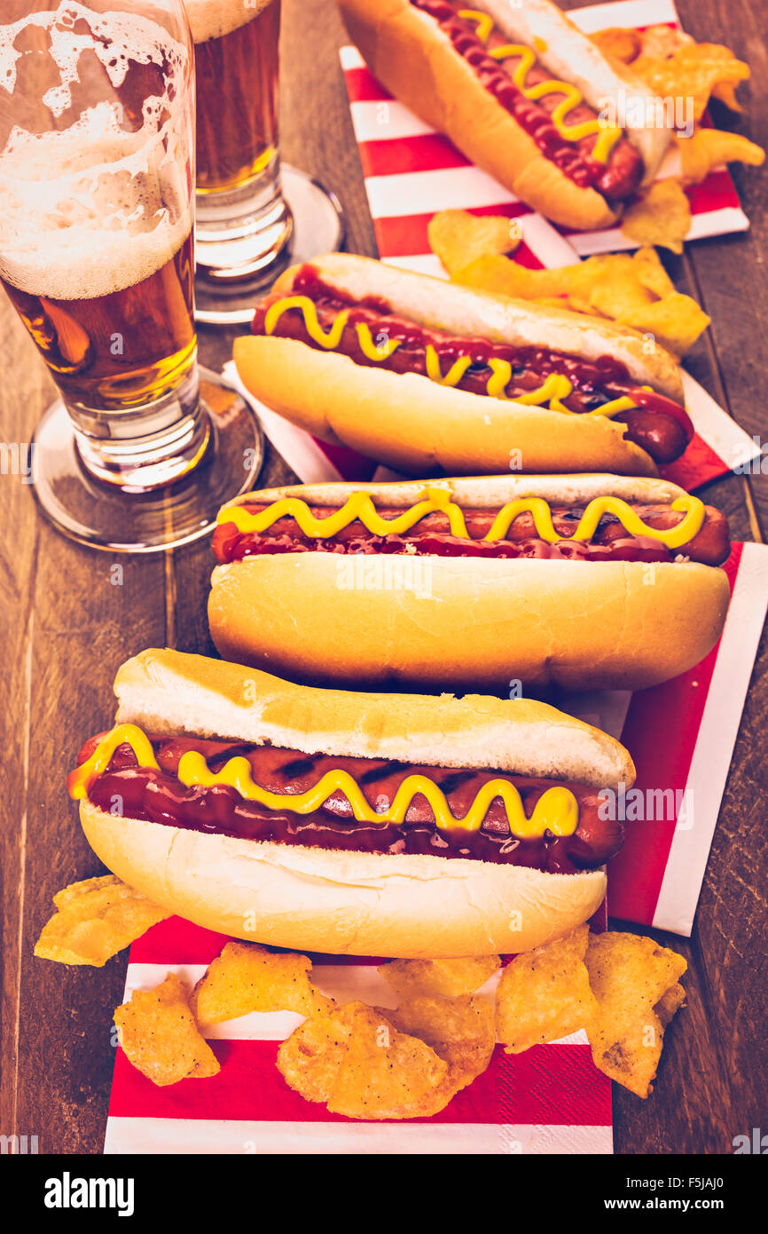 Grigliata di hot dog con senape e ketchup sul tavolo con birra alla spina. Foto Stock