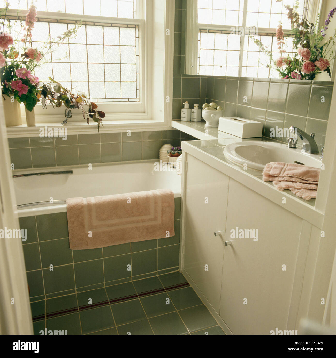 Rosa bathmat sulla vasca da bagno in un verde degli anni settanta in ... Piastrelle bagno verde
