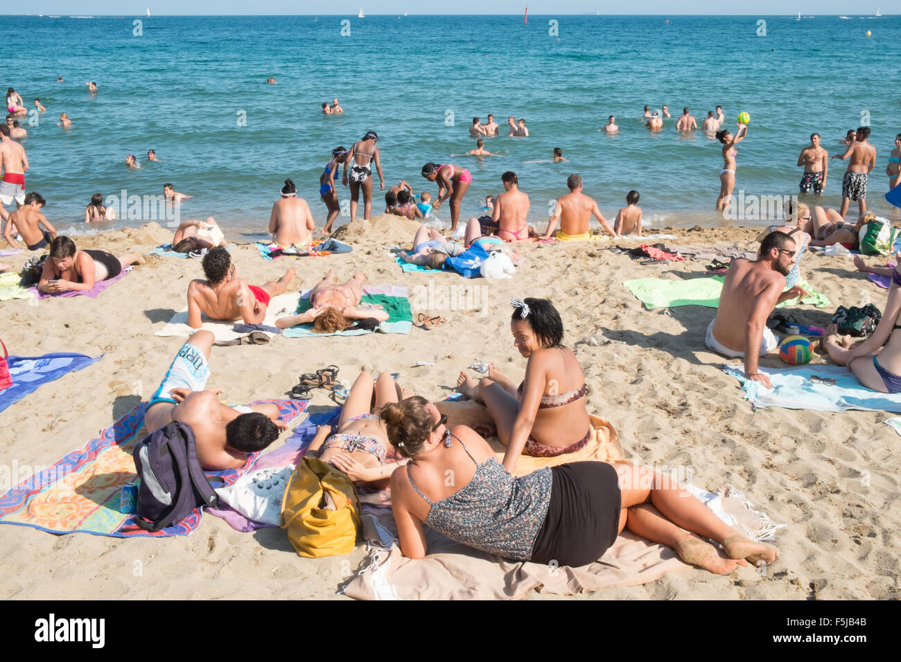 Bagni di sole in spiaggia urbana, Barceloneta,Barcelona.avviso,pericolo,scottature,sun,bruciato,beach,Catalogna,Spagna. Foto Stock