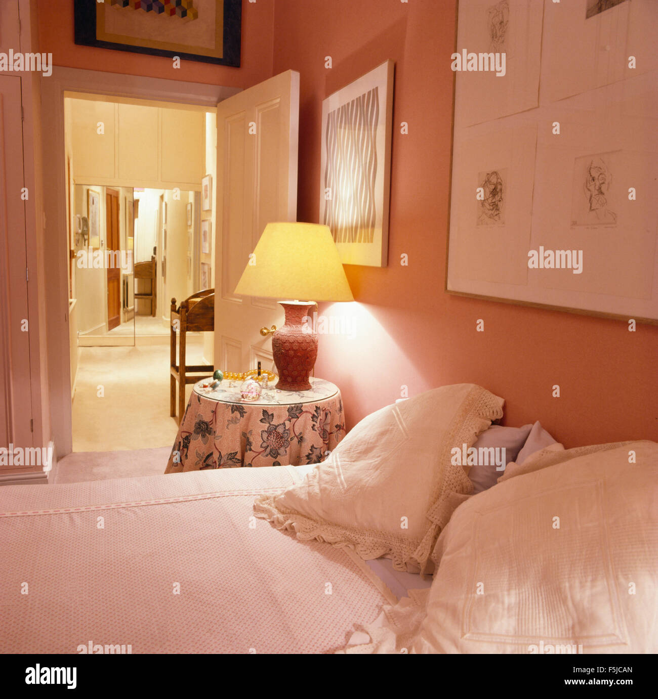 Lampada accesa sul comodino in una rosa la camera da letto degli anni ottanta Foto Stock