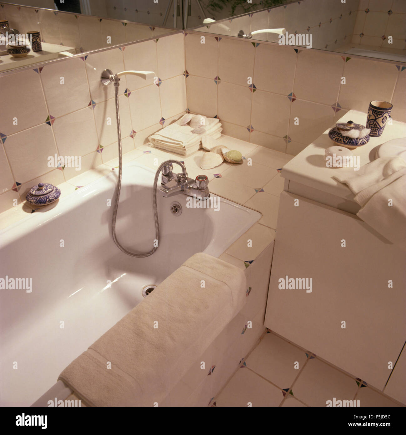 Close-up di vasca da bagno con doccia attacco sulla parete in mattonelle bianche bagno degli anni ottanta Foto Stock