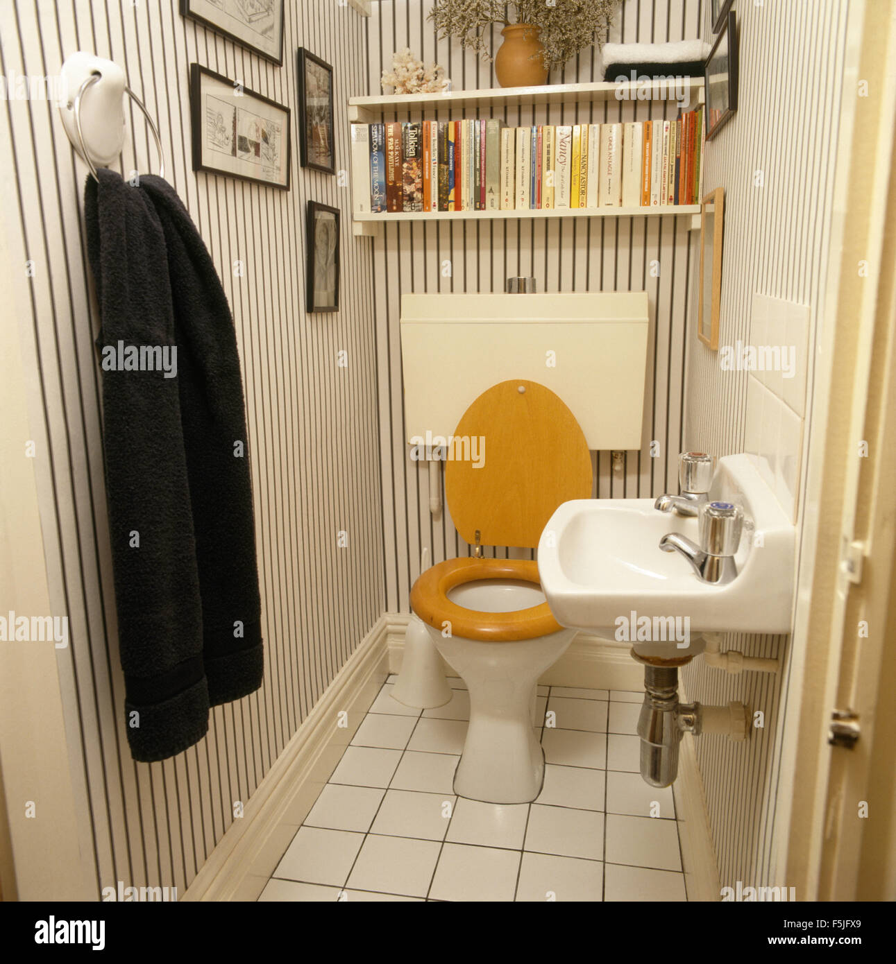 Carta da parati a strisce in settanta guardaroba con sovrastante scaffalatura wc con sedile in legno Foto Stock