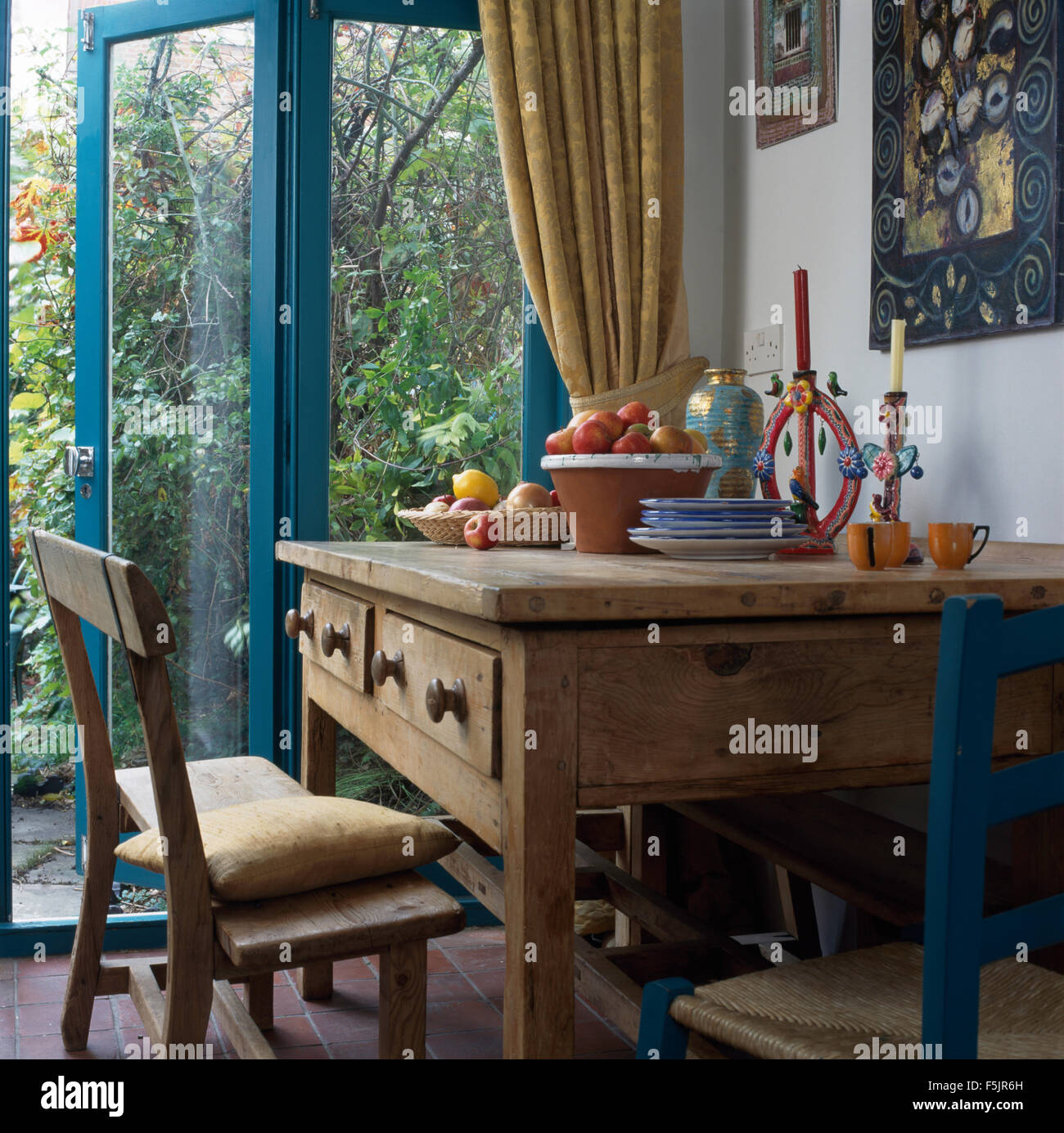 Pino antico tavolo e sedie in novanta soggiorno con apri porta di vetro per il giardino Foto Stock
