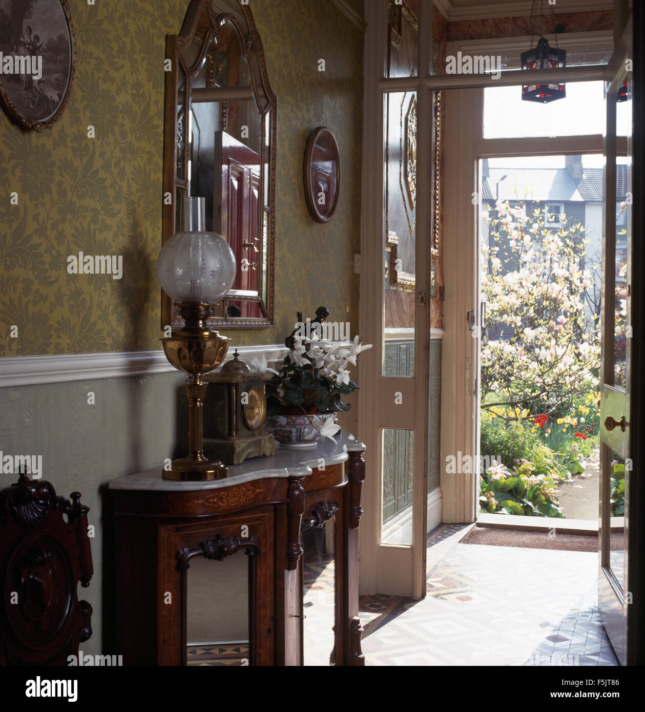 Vetro+ottone Edwardian lampada accesa con ripiano in marmo credenza in townhouse hall Foto Stock