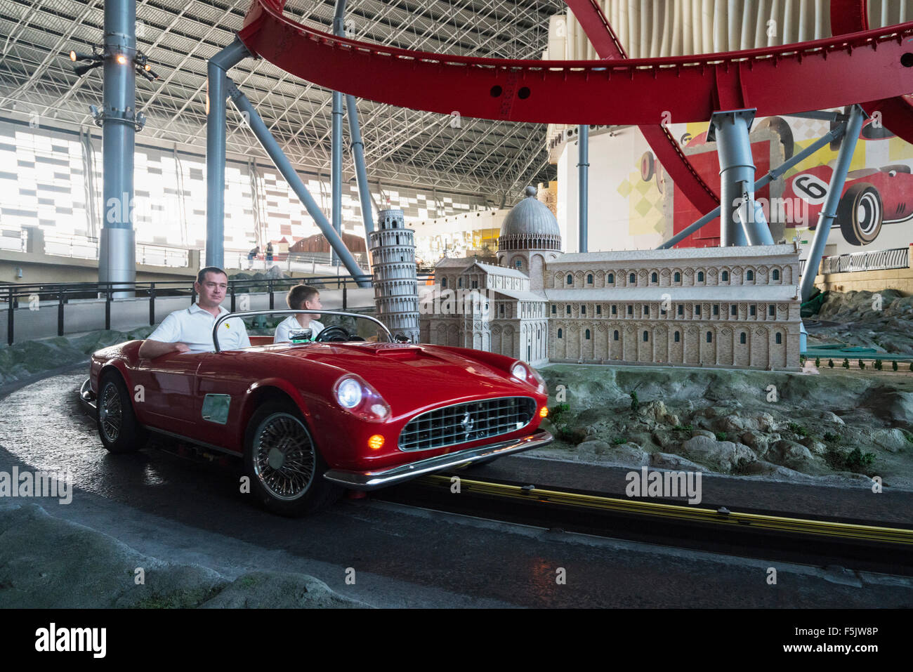 I visitatori a cavallo nel modello auto Ferrari passato italiani famosi punti di riferimento alla Ferrari World Abu Dhabi Emirati Arabi Uniti Foto Stock