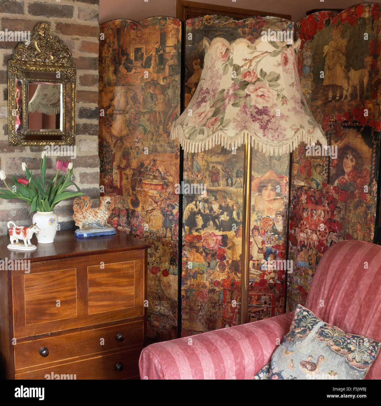 Rose modellato lampada standard e il Victorian decoupaged schermo in un vecchio cottage salotto Foto Stock