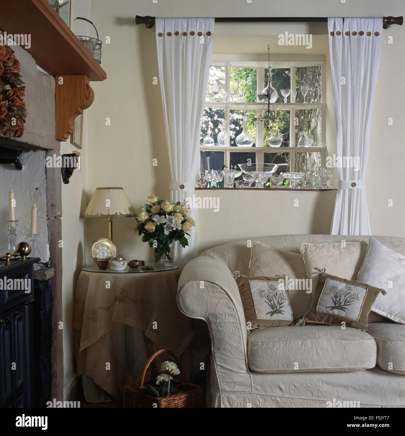 Tende bianche sulla finestra sopra divano bianco in novanta cottage salotto  Foto stock - Alamy
