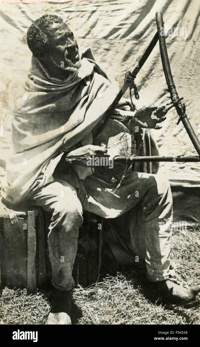 Un uomo giocando a corde dello strumento musicale , Africa orientale Foto Stock