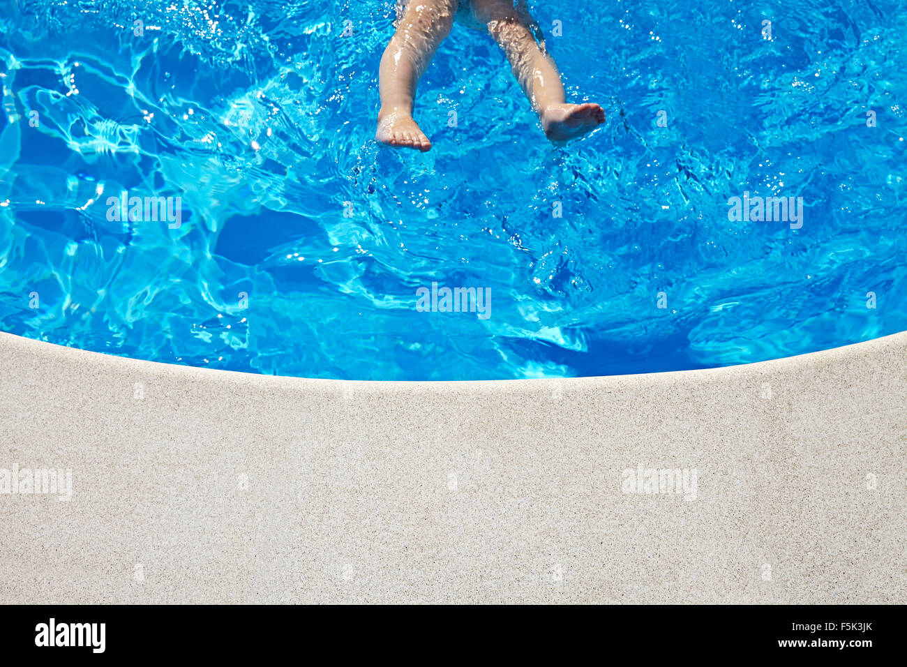 Le gambe del bambino nella piscina in giornata di sole. Copia dello spazio. Foto Stock