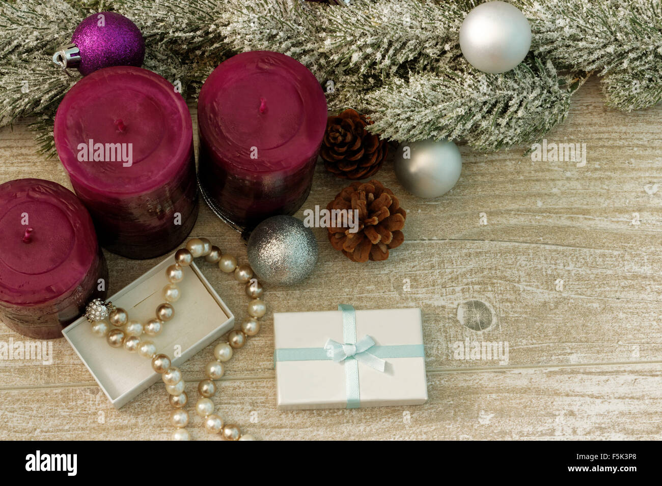 Albero di natale rami, candele e collana di perle in una confezione regalo Foto Stock