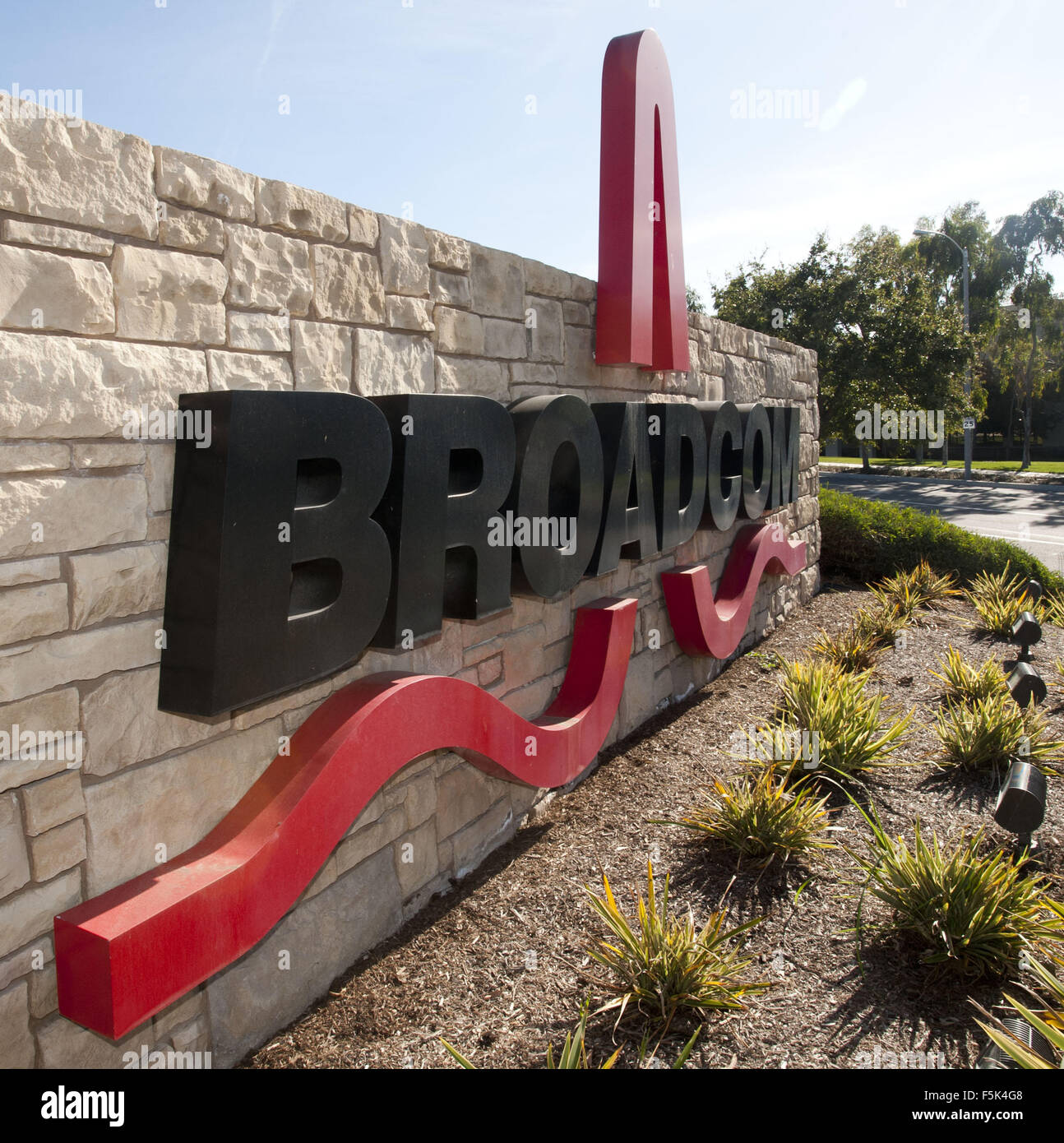 Irvine, California, USA. Decimo gen, 2012. Broadcom è un Irvine (Orange County) basato tech azienda la progettazione e la fabbricazione di chip e micro chip per computer, telefono cellulare e industria del software. Il logo Broadcom offre il nome della società in grassetto nero sans serif font o caratteri con un rosso stilizzato sine impulso elettrico simbolo acceso al di sotto e attraverso il centro del design. Il logo può essere visto nella foto su un lato esterno del marchese o segno che annuncia l'ingresso della società UCI Business campus a Irvine appena fuori la 73 Strada a pedaggio presso il bisonte. (Credito immagine: Foto Stock