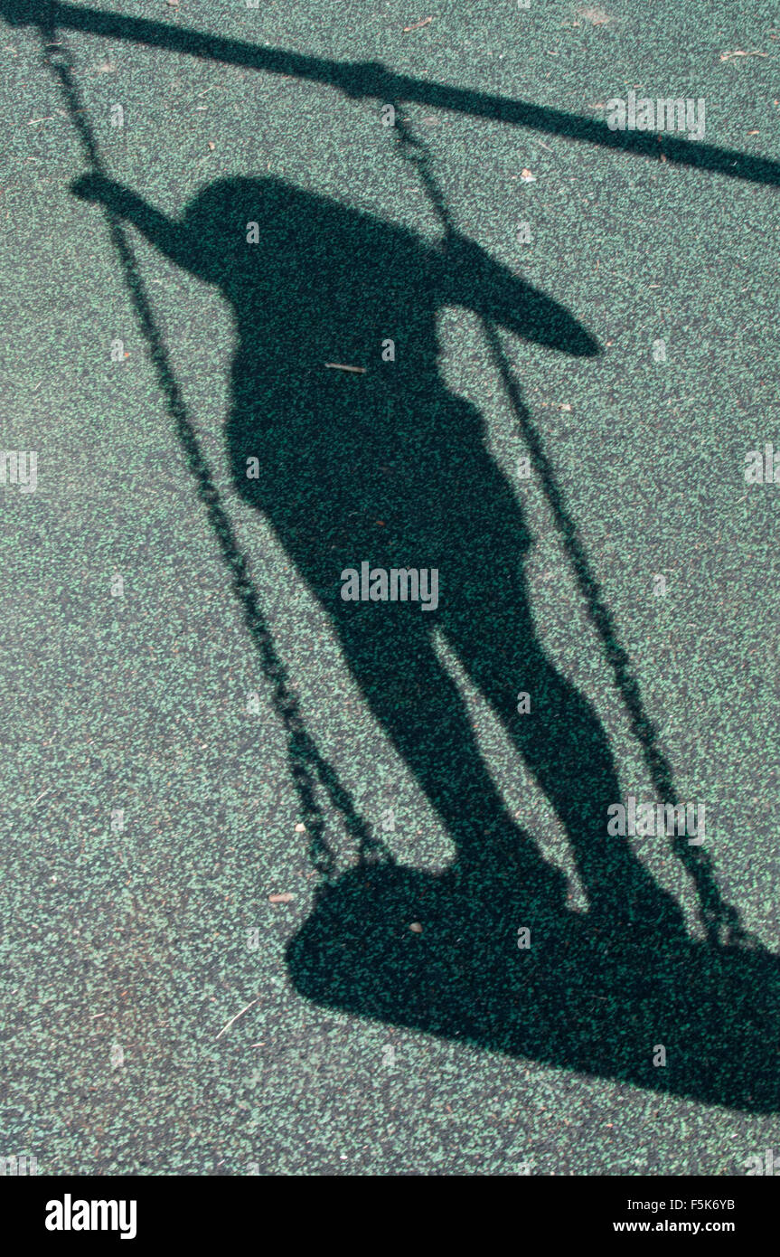 Ombra di una ragazza in piedi su un altalena Foto Stock