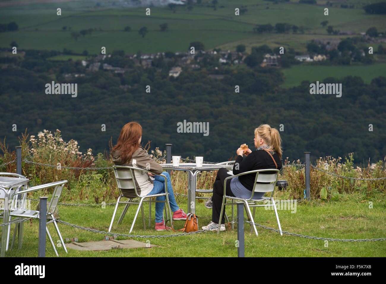 2 donne amici seduti fuori, mangiare e chattare al caffè Cow & Calf Rock, Ilkley, Yorkshire, UK - punto panoramico con vista panoramica sulla valle. Foto Stock