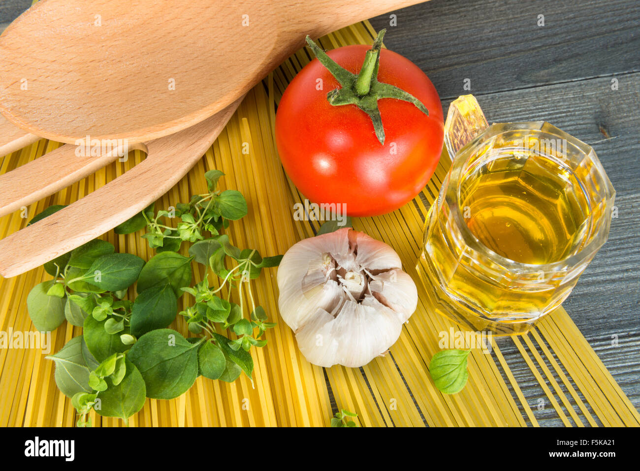 Ingredienti di base per cucinare gli spaghetti su un tavolo di legno Foto Stock
