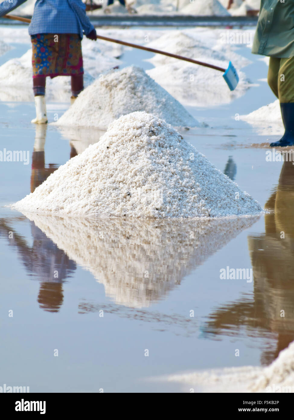 Agricoltore la rastrellatura nel campo di sale in Thailandia Foto Stock