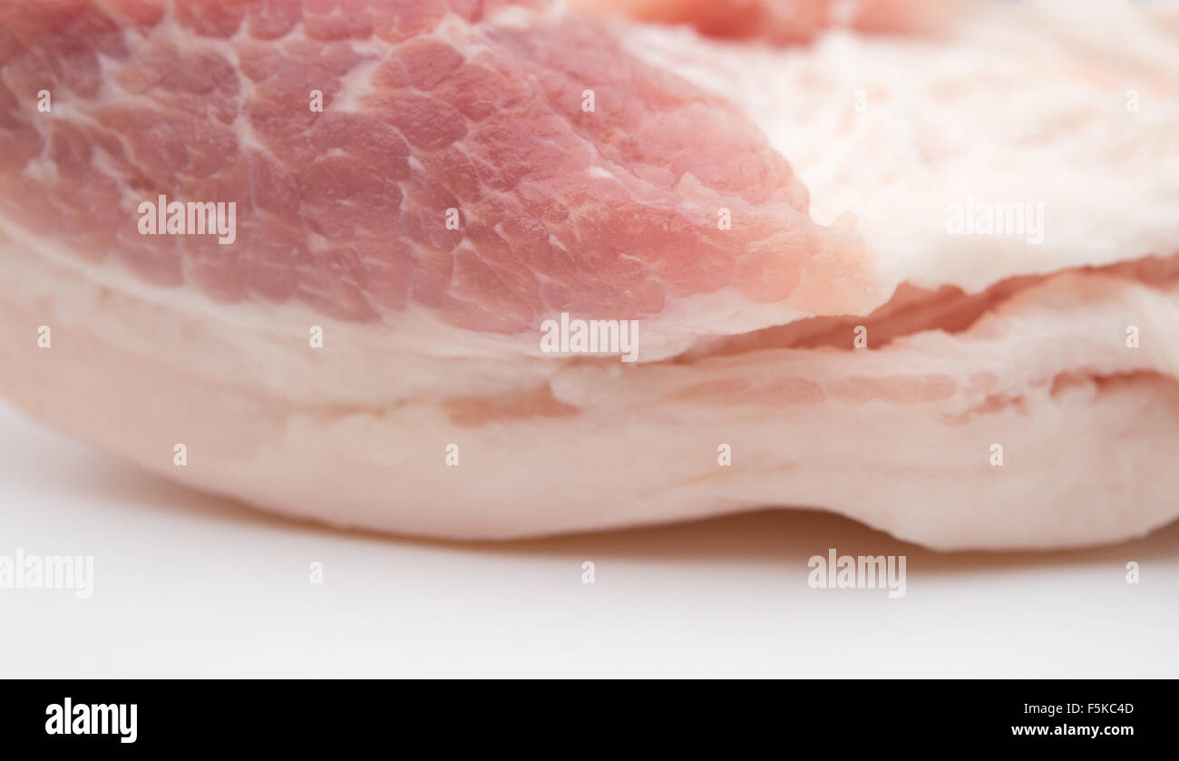 Molto grassa carne di maiale cruda in uno sfondo bianco Foto Stock