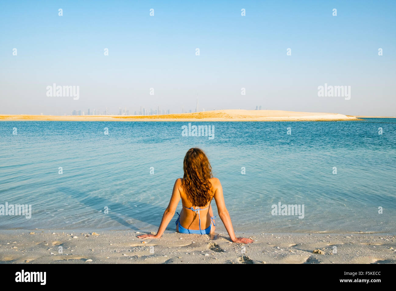 Donna sulla spiaggia presso l'isola il Libano beach resort su un uomo fatto isola, parte del mondo fuori della costa di Dubai in United Arab Emirat Foto Stock