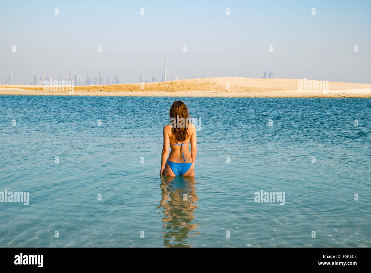 Donna in mare a Isola il Libano beach resort su un uomo fatto isola, parte del mondo fuori della costa di Dubai negli Emirati Arabi Uniti Foto Stock