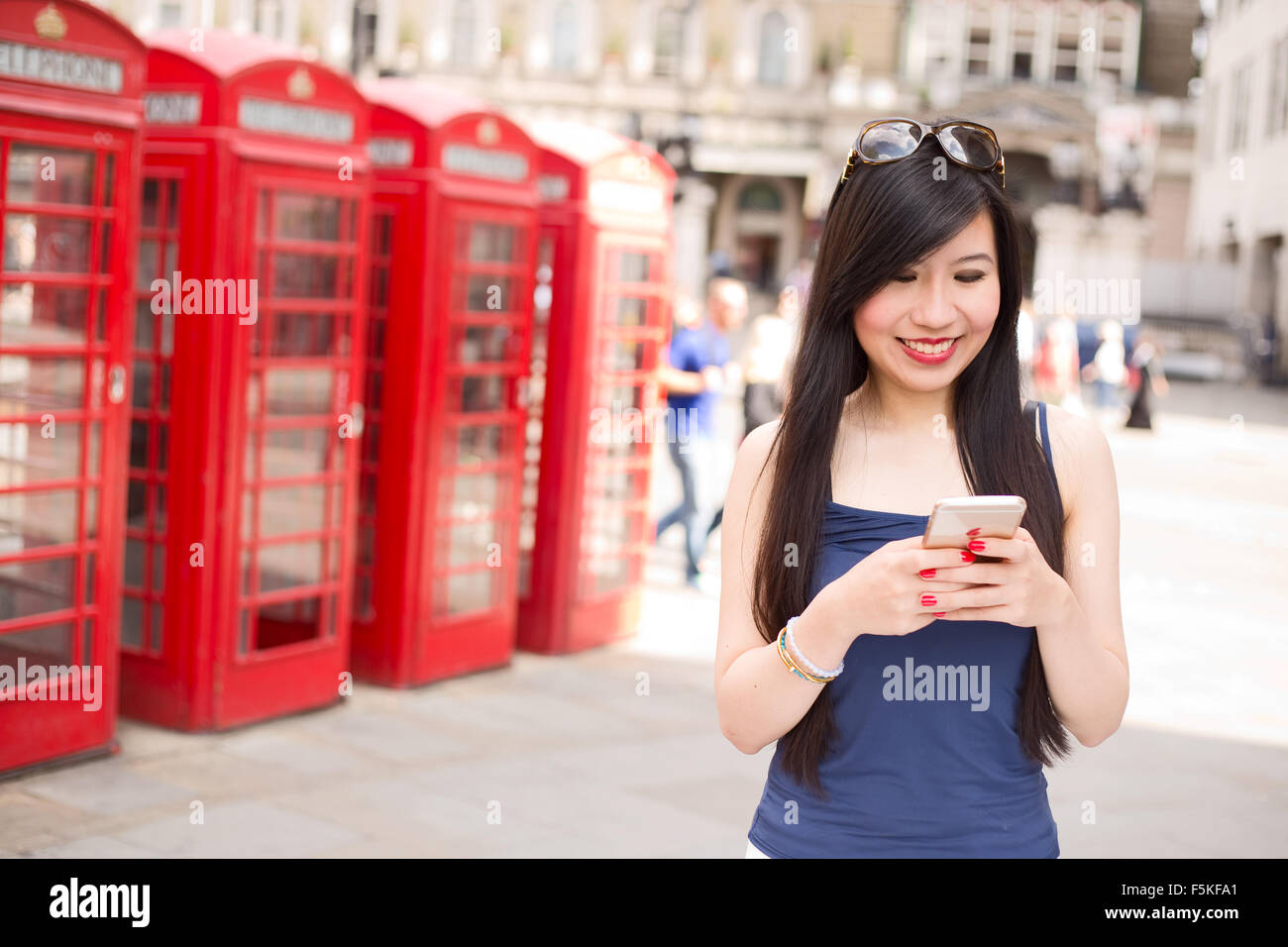 Donna giapponese a Londra l'invio di un messaggio di testo Foto Stock
