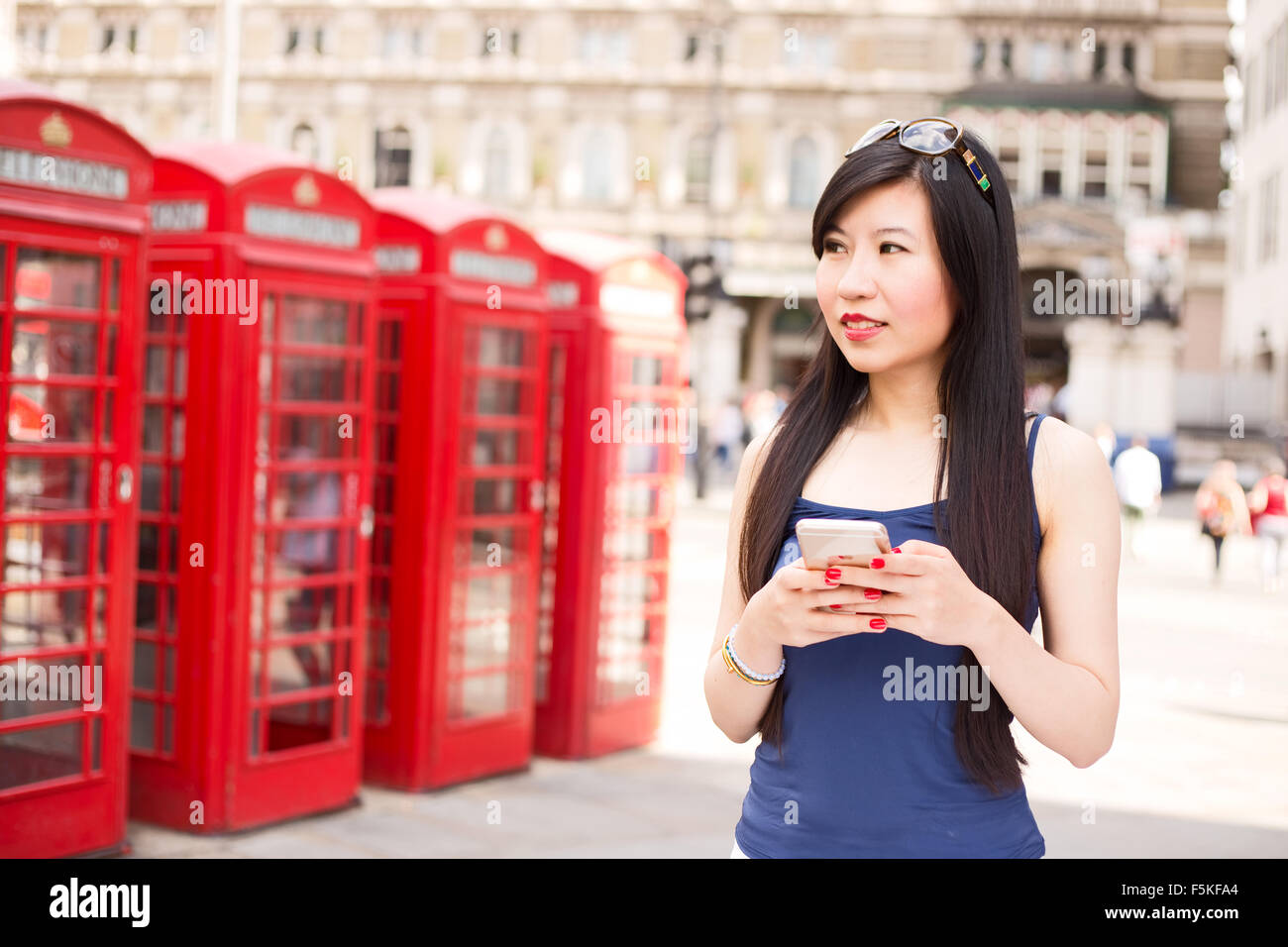 Donna giapponese a Londra con il suo telefono cellulare Foto Stock
