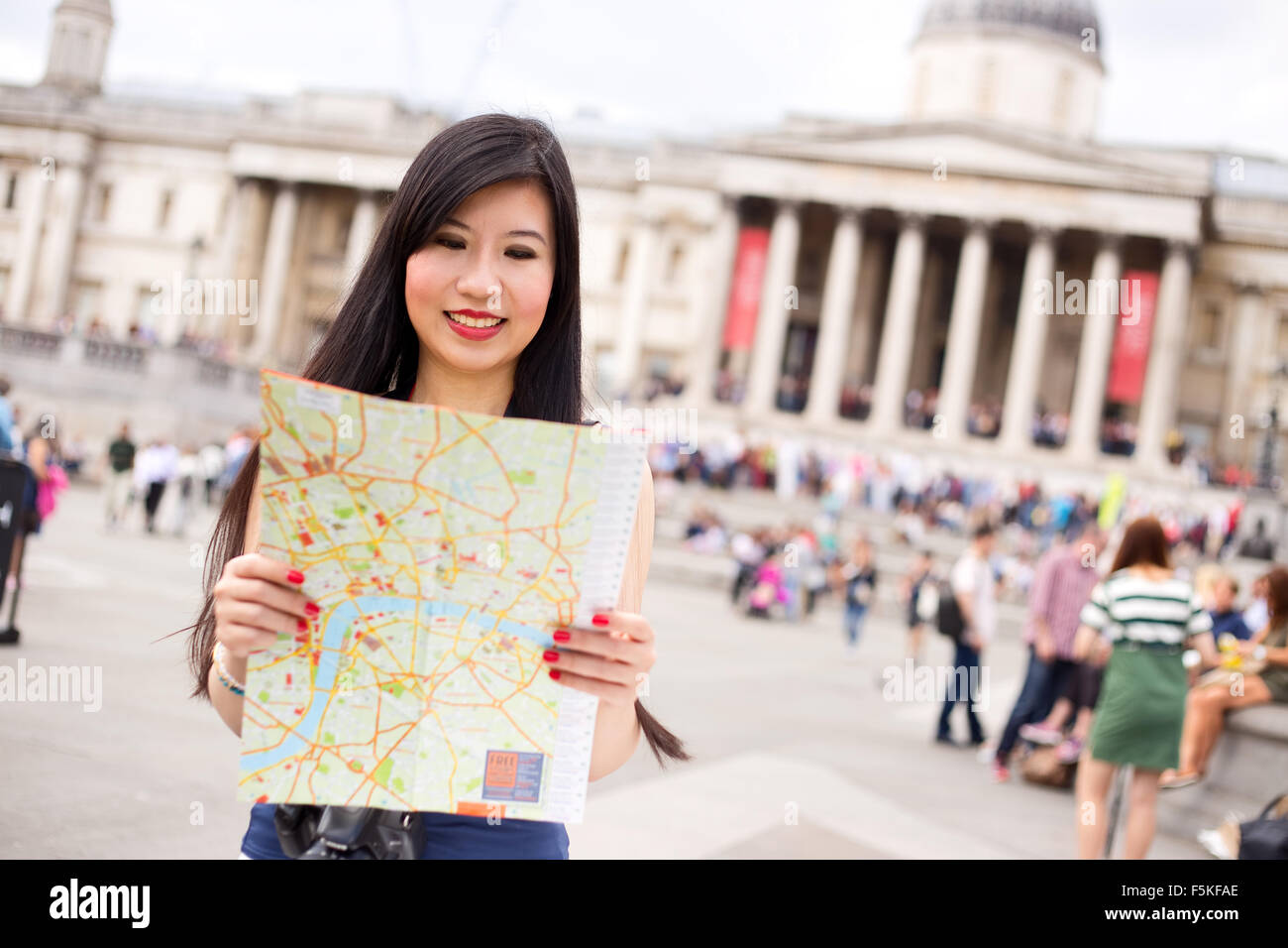 Donna giapponese in Trafalgar square e la lettura di una mappa Foto Stock