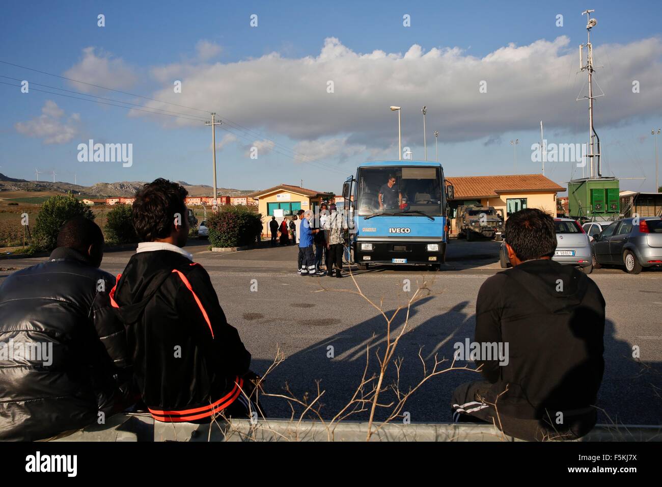 Catania, Italia. 4 Novembre, 2015. Richiedenti asilo guardare le persone che stanno andando a negozi nelle città vicine a bordo di un pulmann al di fuori Cara di Mineo, in Europa il più grande centro di accoglienza per i richiedenti asilo, circa 70 km ad ovest dalla città di porto di Catania in Sicilia, Italia, nov. 4, 2015. Il composto di 404 case e altre strutture diventa ora una casa temporanea per circa 1.700 richiedenti asilo dal Mali, Gambia, Costa d'Avorio e in altri 14 paesi. © Ye Pingfan/Xinhua/Alamy Live News Foto Stock