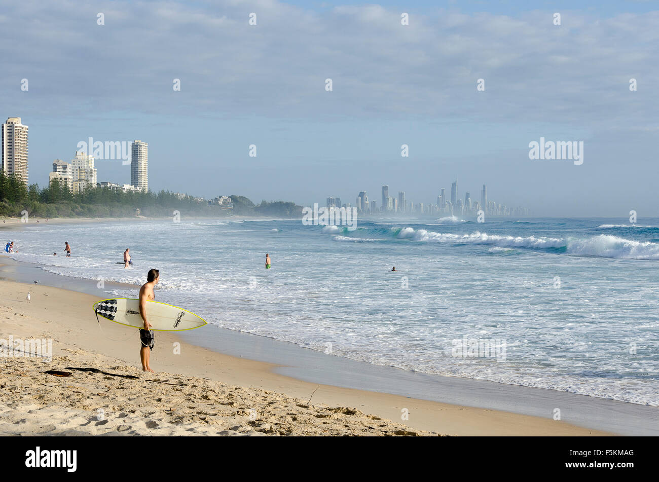 Surfisti a Burleigh teste, blocco a torre di appartamenti a Surfers Paradise in distanza, Queensland, Australia Foto Stock