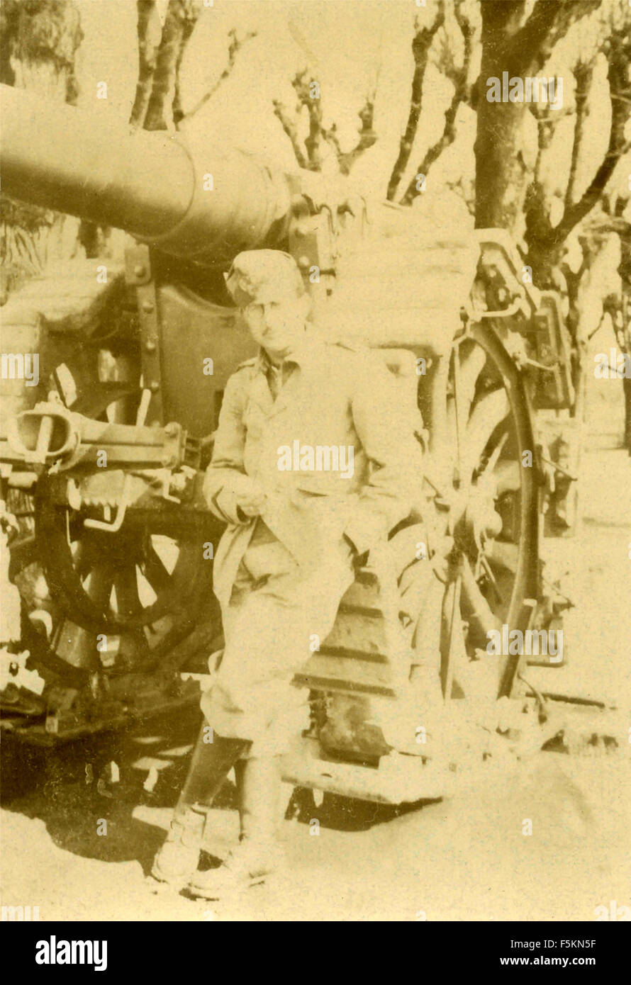 Un esercito italiano soldato accanto a un cannone Foto Stock