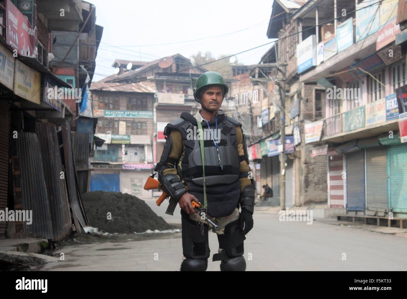 Poliziotto indiano stand durante un coprifuoco a Srinagar. Foto Stock