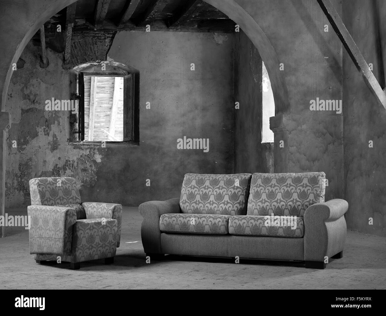 Divano e poltrona in un grande vuoto interno con finestra aperta in bianco e nero in verticale Foto Stock