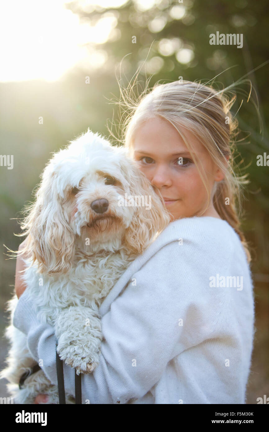 La Svezia, Uppland, Lanna, ragazza (12-13) tenendo il cane Foto Stock