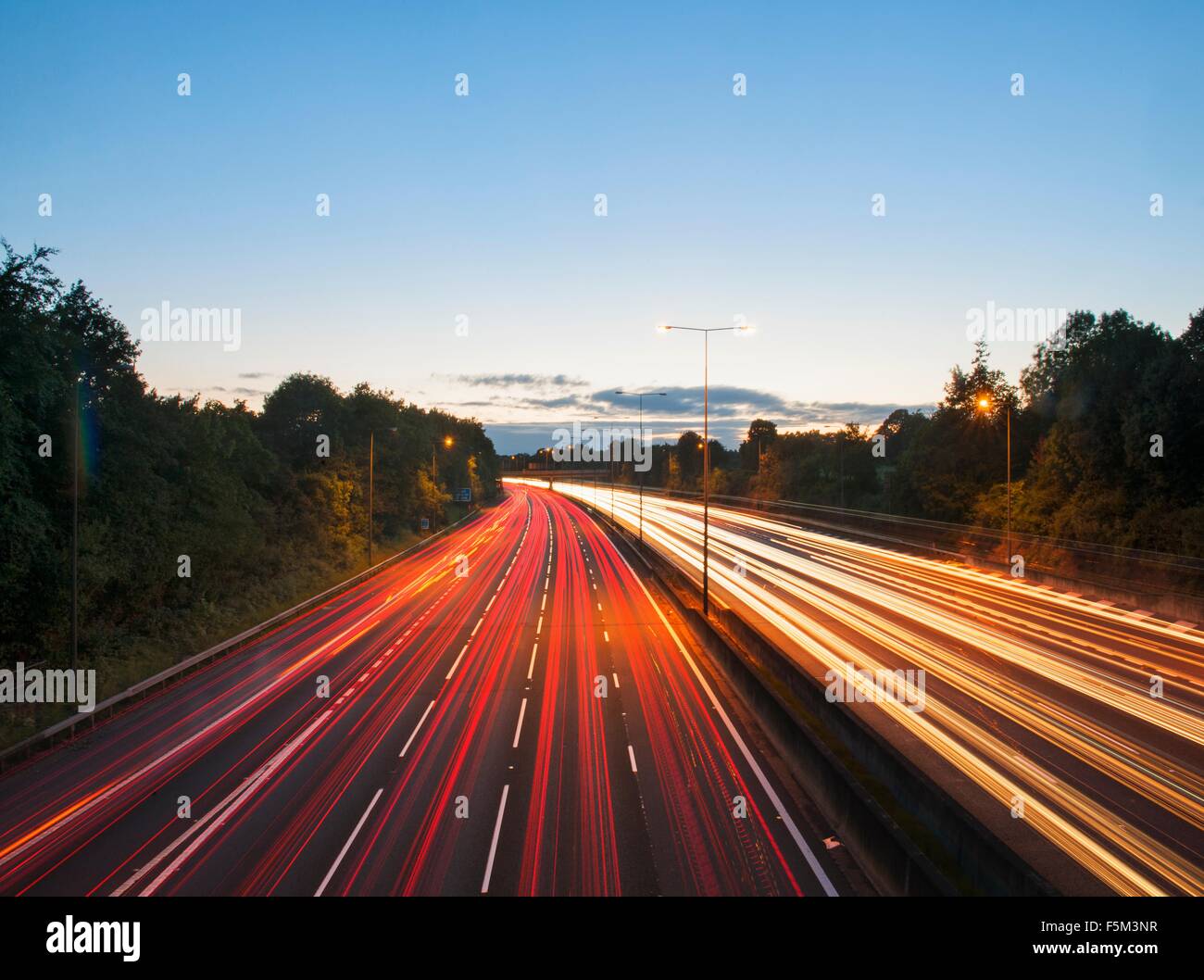 Vista in elevazione del traffico autostradale sentieri di luce al tramonto Foto Stock