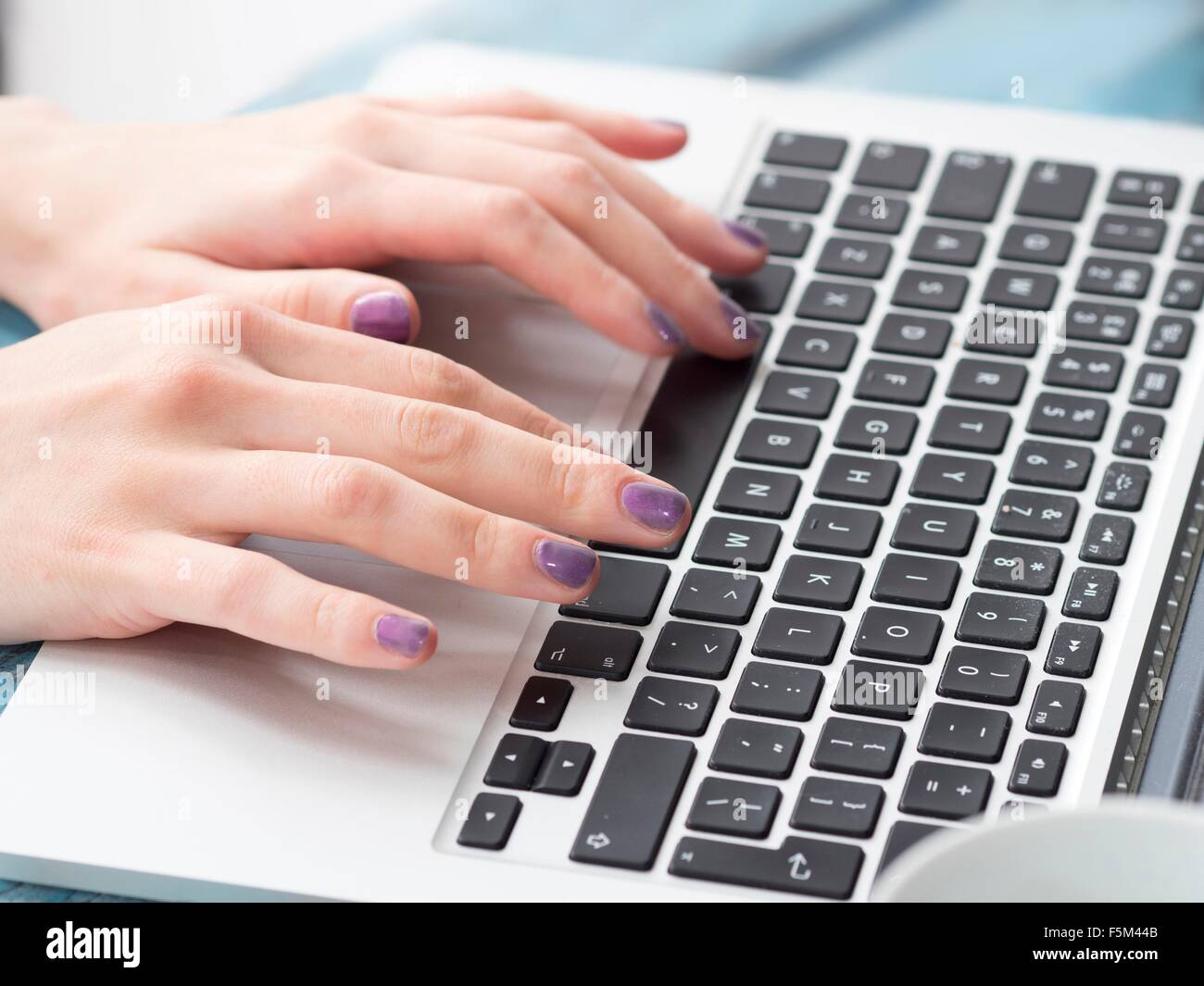 Giovane donna digitando sulla tastiera del notebook, concentrarsi sulle mani Foto Stock