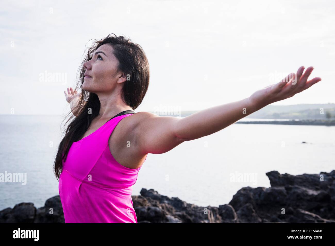 La donna a costa la pratica dello yoga con i bracci aperti, punto Hawea, Maui, Hawaii, STATI UNITI D'AMERICA Foto Stock