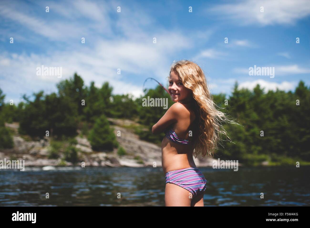 Ragazza in Bikini pesca, re sul Lago Ontario, Canada Foto Stock